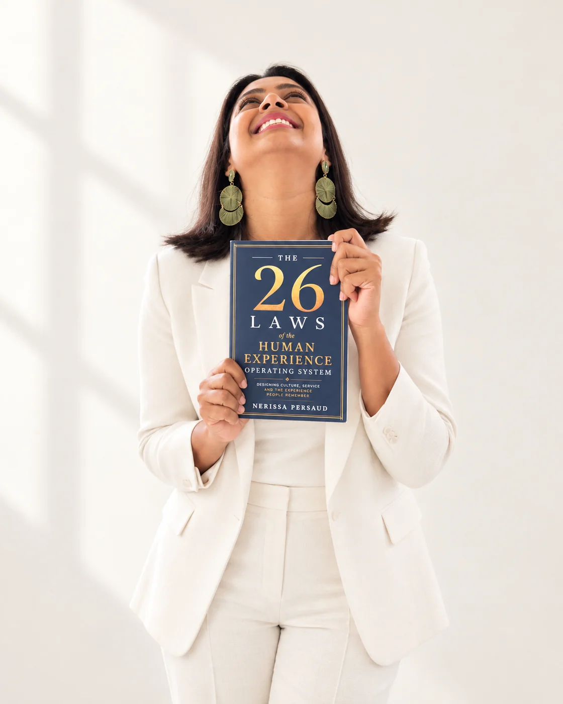 Nerissa smiling upwards while holding The 26 Laws